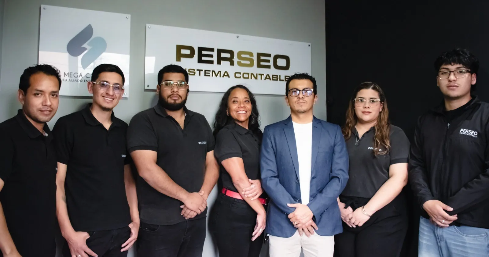 El equipo de MegaConta en su oficina de Cuenca, frente a los letreros de MegaConta y de Perseo Sistema Contable
